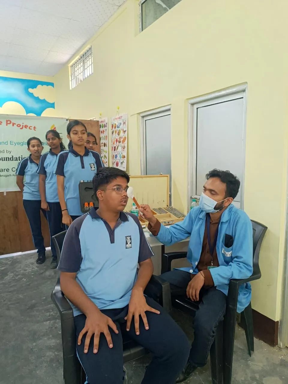 Ophthalmic assistant conducting visual acuity tests for local residents.